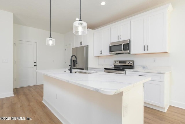 kitchen featuring white cabinetry, appliances with stainless steel finishes, a kitchen island with sink, and light wood-style flooring