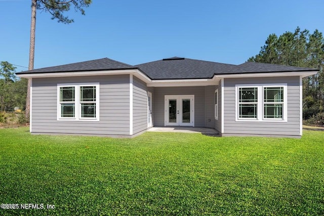 rear view of property with a yard, a shingled roof, and french doors