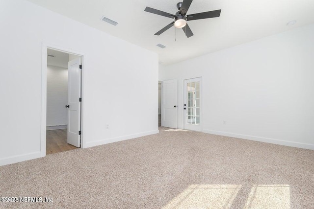 unfurnished room featuring baseboards, a ceiling fan, visible vents, and carpet