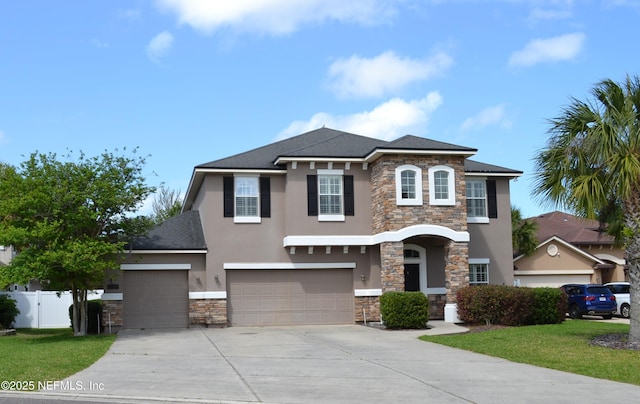 view of front of property with stone siding, stucco siding, driveway, an attached garage, and roof with shingles