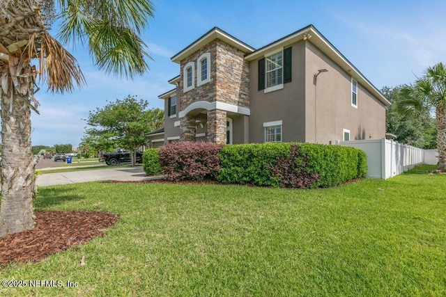 view of property exterior with stucco siding, stone siding, and driveway