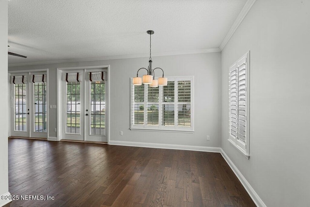 unfurnished dining area featuring a chandelier, crown molding, dark wood-style floors, baseboards, and a textured ceiling