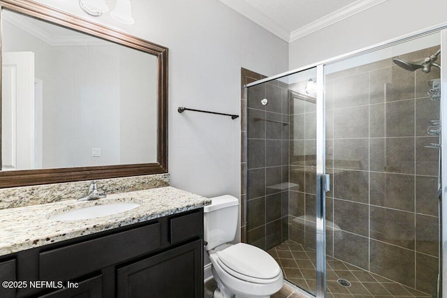 bathroom with a shower stall, toilet, vanity, and crown molding
