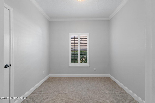 spare room with light colored carpet, crown molding, and baseboards