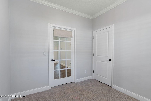 doorway to outside with crown molding, carpet flooring, and baseboards