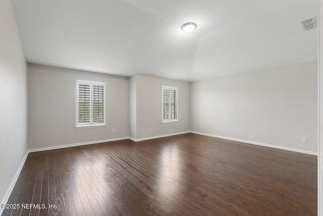 empty room featuring dark wood-style flooring and baseboards