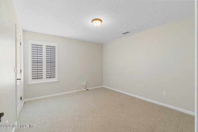 carpeted empty room featuring baseboards and a textured ceiling
