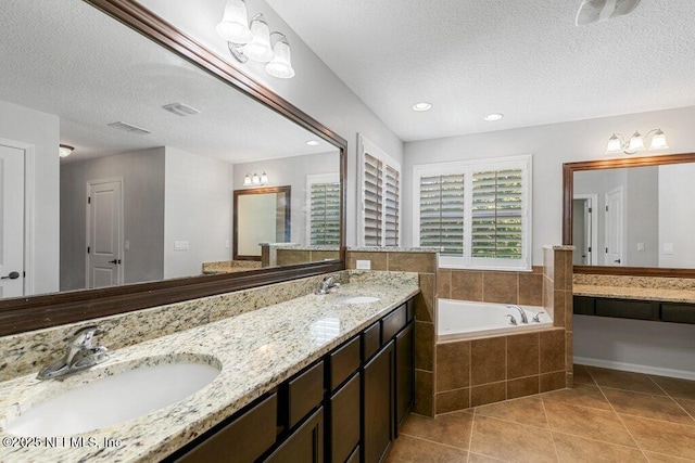full bath with tile patterned flooring, a bath, a textured ceiling, double vanity, and recessed lighting