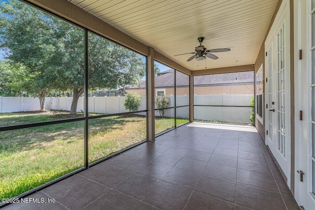 unfurnished sunroom featuring a ceiling fan