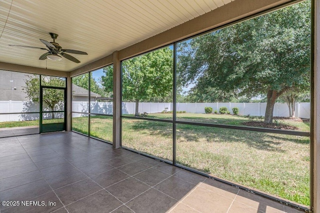 unfurnished sunroom featuring ceiling fan and healthy amount of natural light