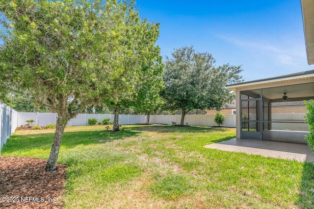 view of yard with a sunroom and ceiling fan
