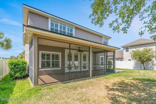 back of property with a sunroom, stucco siding, a ceiling fan, and french doors