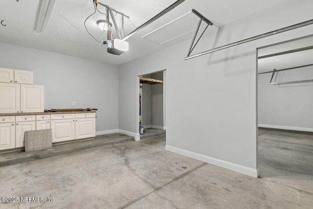 garage with a garage door opener and baseboards