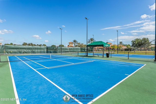 view of tennis court featuring fence