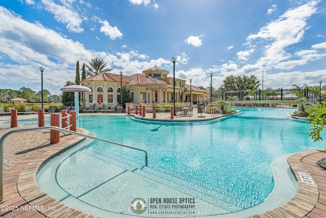 community pool featuring a patio and fence