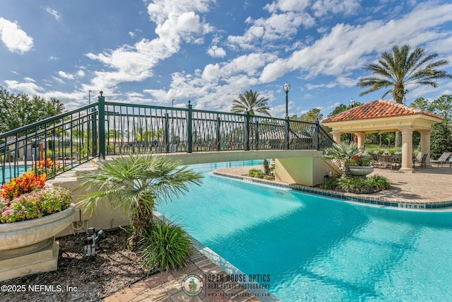 community pool with a gazebo and fence