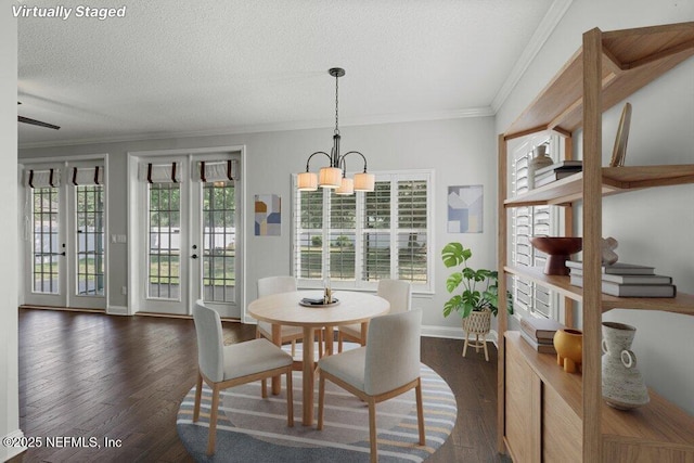 dining space featuring a chandelier, crown molding, dark wood-style flooring, baseboards, and french doors