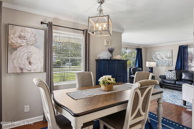 dining room featuring an inviting chandelier, wood finished floors, crown molding, and baseboards