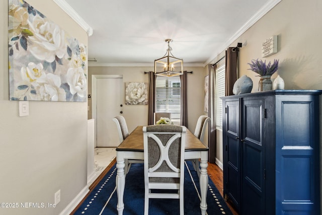 dining space featuring baseboards, a notable chandelier, and crown molding