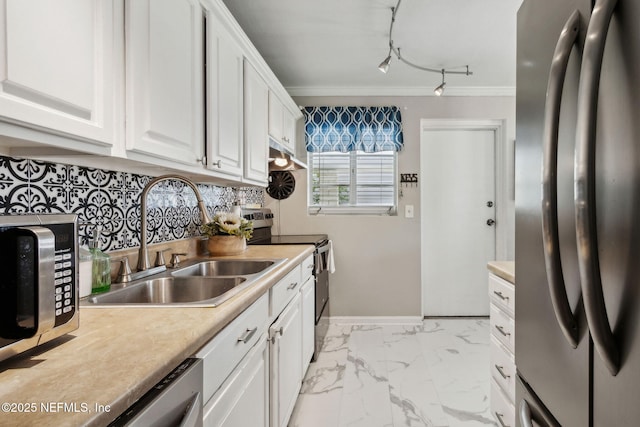 kitchen with light countertops, stainless steel appliances, crown molding, and a sink