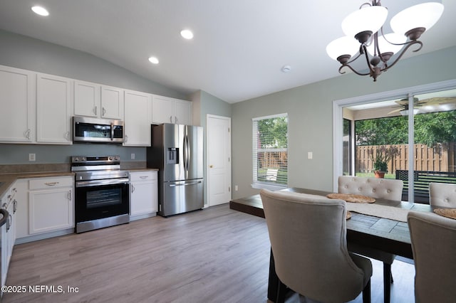 76044 Deerwood Dr, Yulee, FL 32097 - kitchen featuring stainless steel appliances, vaulted ceiling, recessed lighting, a chandelier, and white cabinetry