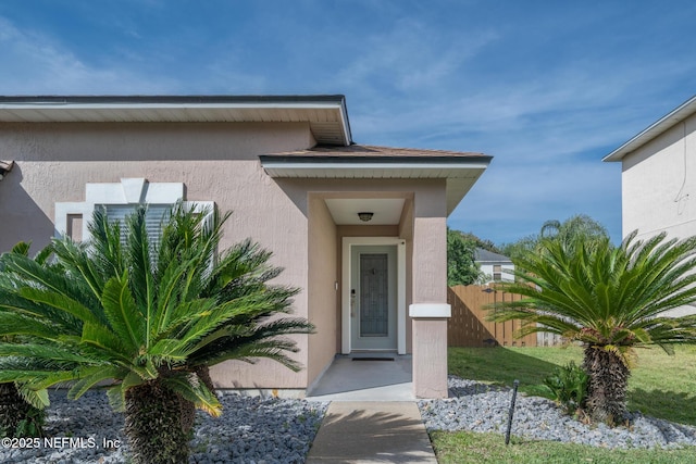 76044 Deerwood Dr, Yulee, FL 32097 - doorway to property featuring stucco siding and fence