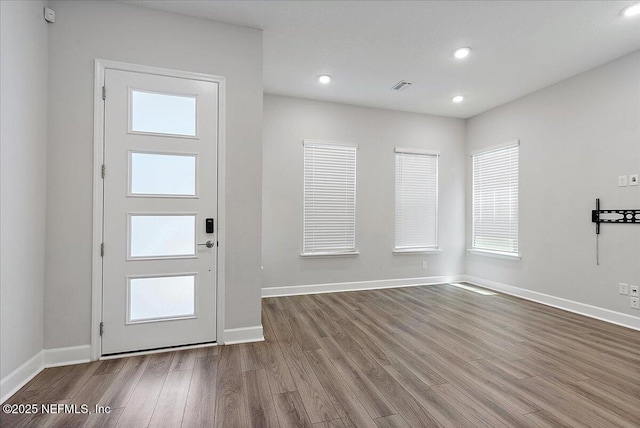 foyer with baseboards, recessed lighting, wood finished floors, and visible vents