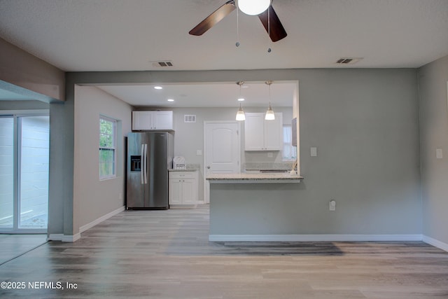kitchen with white cabinets, visible vents, baseboards, light wood-type flooring, and stainless steel refrigerator with ice dispenser