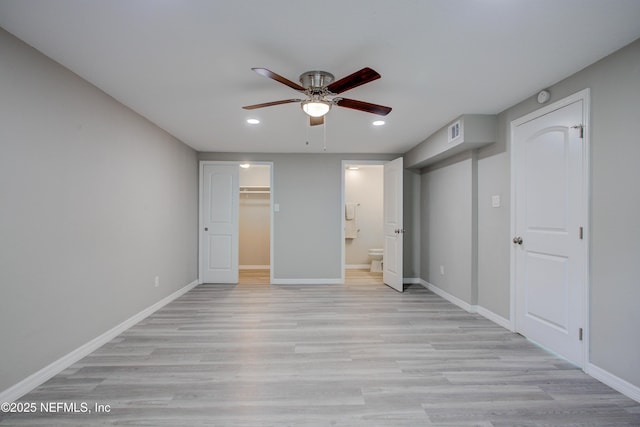 unfurnished bedroom featuring baseboards, light wood-type flooring, a spacious closet, and recessed lighting