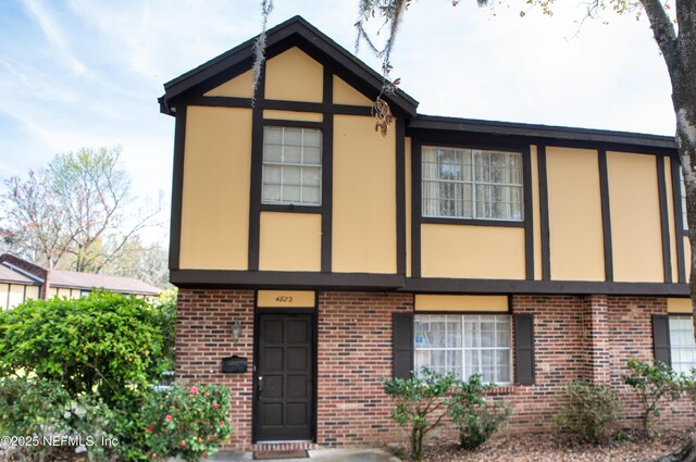 view of front of house featuring stucco siding and brick siding
