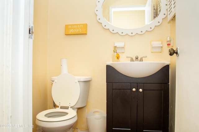 half bathroom with vanity and toilet