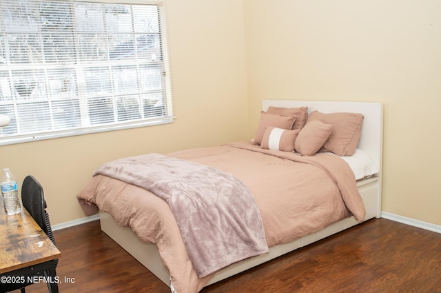 bedroom featuring baseboards and wood finished floors
