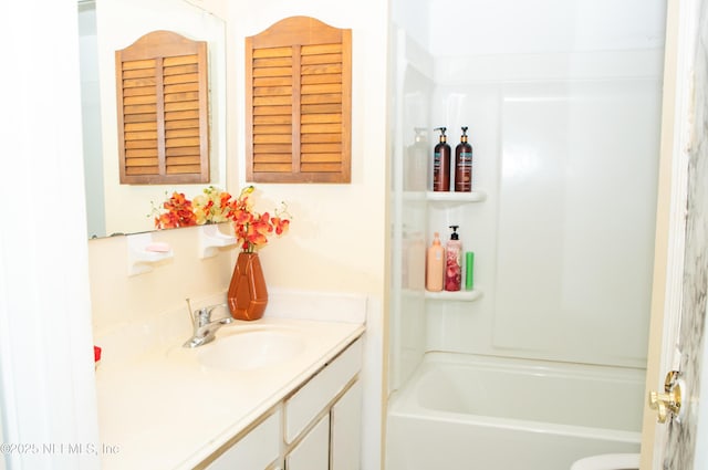 bathroom featuring toilet, vanity, and  shower combination