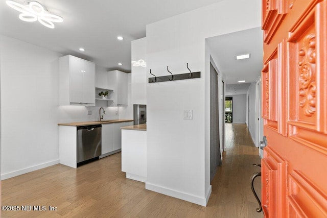 kitchen featuring open shelves, light wood-style flooring, white cabinetry, stainless steel dishwasher, and modern cabinets
