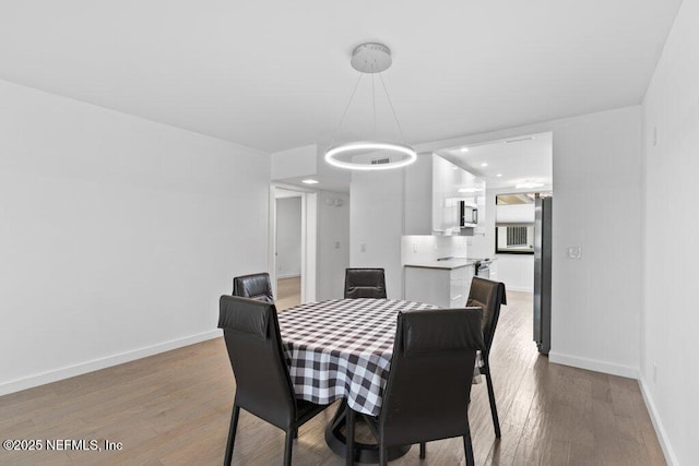 dining space with baseboards, recessed lighting, and wood finished floors