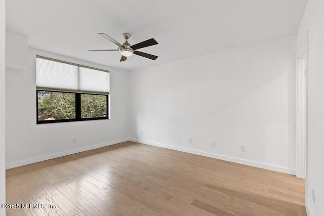 spare room with baseboards, ceiling fan, and light wood-style flooring
