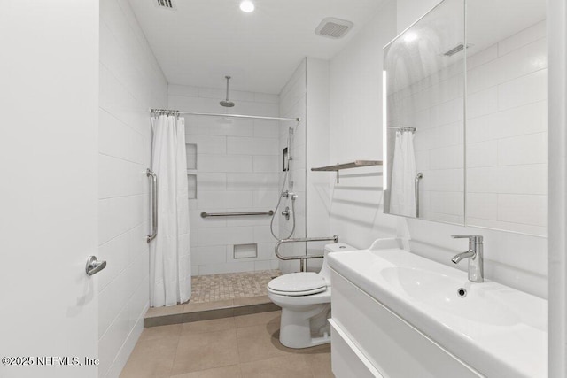bathroom with vanity, visible vents, toilet, and tiled shower