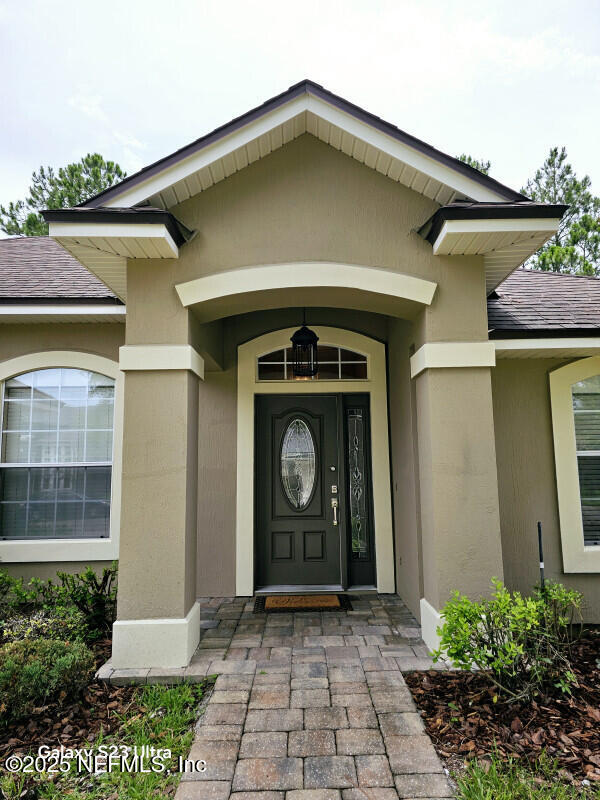 view of exterior entry with stucco siding
