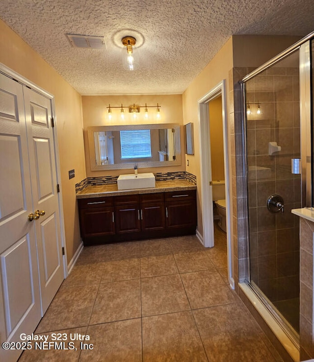 full bath featuring a shower stall, visible vents, toilet, and vanity