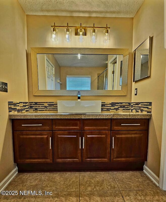 bathroom featuring tasteful backsplash, baseboards, and a shower with door