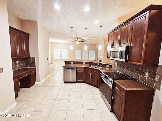 kitchen with a peninsula, dark countertops, recessed lighting, ceiling fan, and appliances with stainless steel finishes