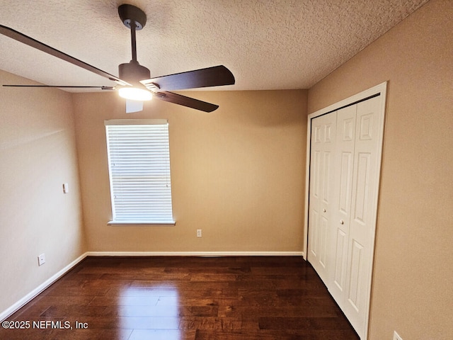 unfurnished bedroom with wood finished floors, a closet, baseboards, a textured ceiling, and ceiling fan