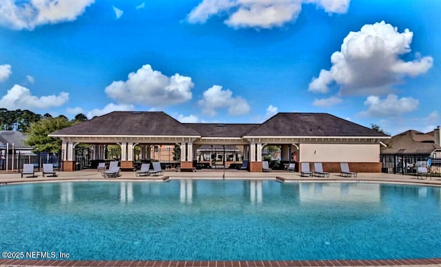 community pool with a gazebo, a patio, and fence