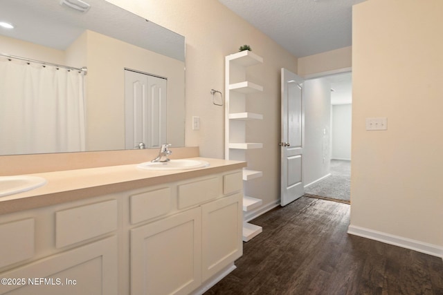 4402 Warm Springs Way, Middleburg, FL 32068 - bathroom with wood finished floors, double vanity, a textured ceiling, and baseboards
