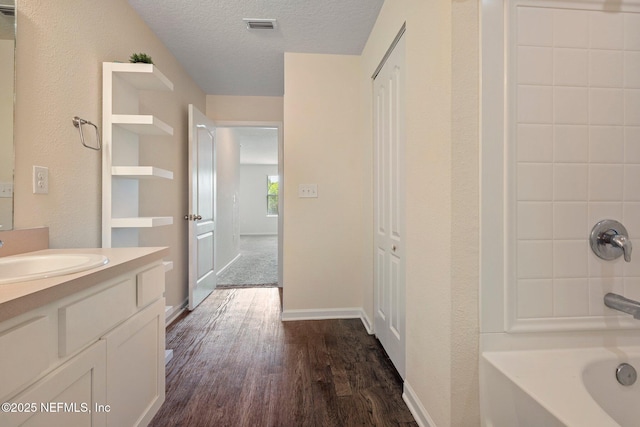 4402 Warm Springs Way, Middleburg, FL 32068 - full bathroom featuring wood finished floors, vanity, bathtub / shower combination, a textured ceiling, and baseboards