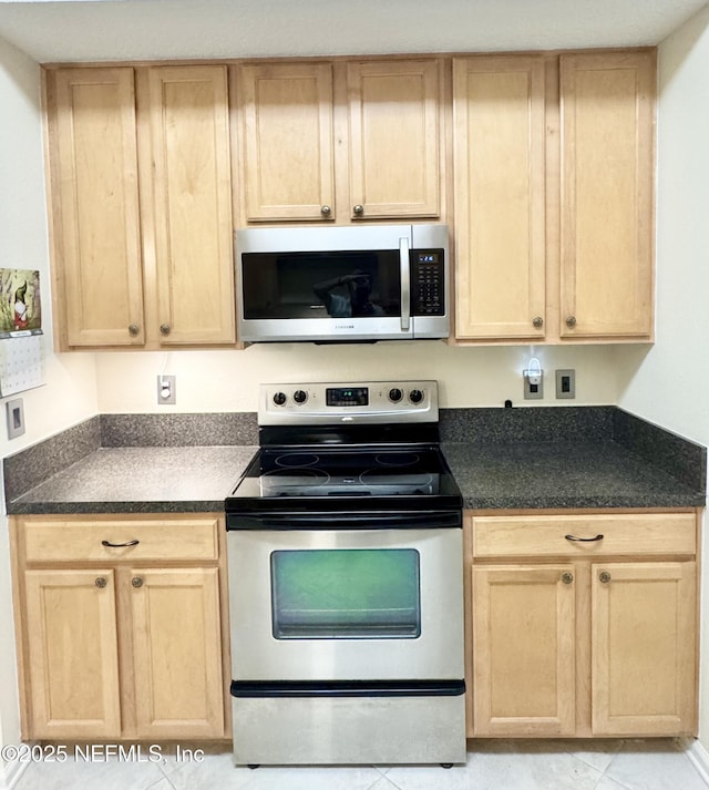 9421 Osprey Branch Trl Unit 4, Jacksonville, FL 32257 - kitchen featuring dark countertops, light brown cabinetry, and appliances with stainless steel finishes