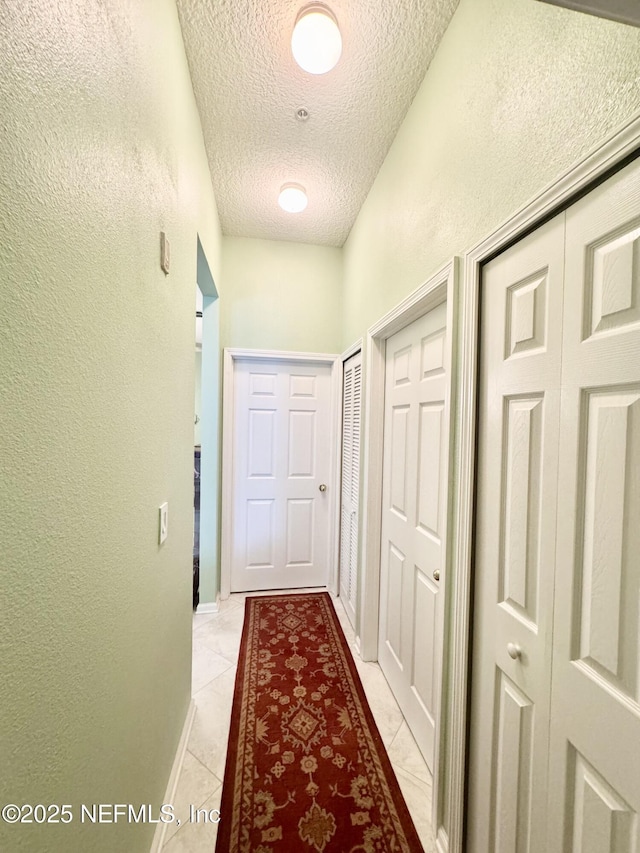 9421 Osprey Branch Trl Unit 4, Jacksonville, FL 32257 - hall featuring a textured ceiling, a textured wall, and light tile patterned flooring