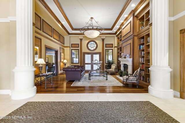 interior space featuring ornate columns, ornamental molding, a high ceiling, and tile patterned floors