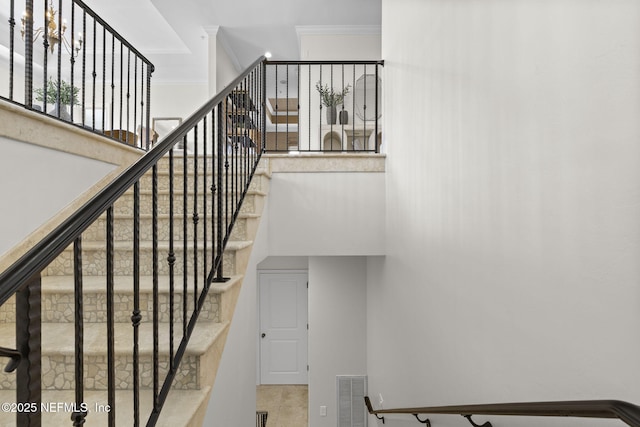 stairway featuring visible vents, ornamental molding, and tile patterned floors