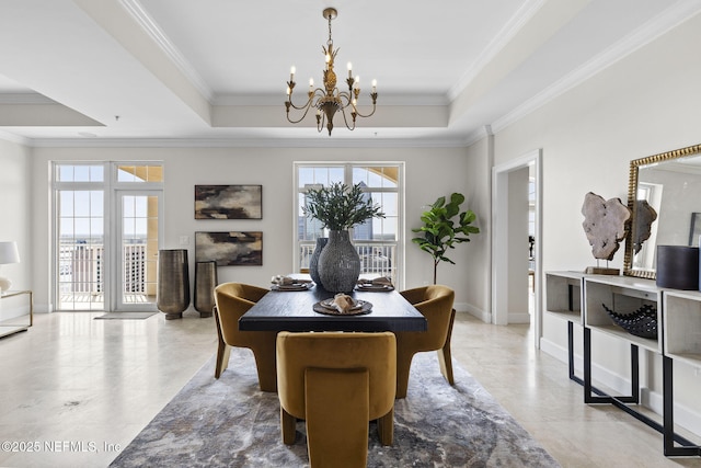 dining room with an inviting chandelier, a raised ceiling, and crown molding